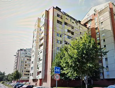a tall building with a street sign in front of it at BK Apartment in Niš