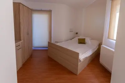 a small bedroom with a bed in the corner at Vila Nikola Nature and Mind Retreat House