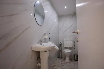 a white bathroom with a sink and a toilet at Vila Nikola Nature and Mind Retreat House