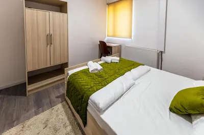 a bedroom with a large bed with a green blanket at Vila Nikola Nature and Mind Retreat House