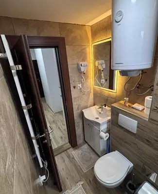 a bathroom with a toilet and a sink and a mirror at Monte LUX 10 in Kopaonik