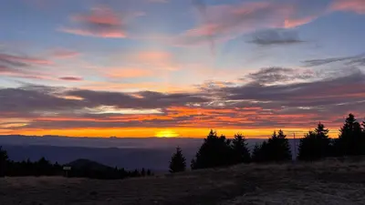 a sunset on the top of a mountain with trees at Monte LUX 10 in Kopaonik