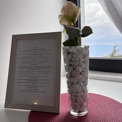 a vase with a flower in it next to a picture frame at Monte LUX 10 in Kopaonik