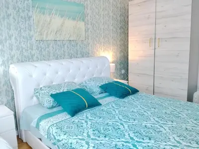 a bedroom with a white bed with blue pillows at Magnolia Lux Apartments - komplex Green Hill in Soko Banja
