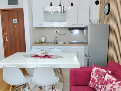 a kitchen with a white table and white chairs at Magnolia Lux Apartments - komplex Green Hill in Soko Banja