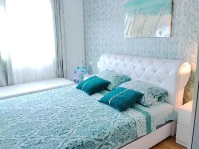 a bedroom with a bed with blue sheets and blue pillows at Magnolia Lux Apartments - komplex Green Hill in Soko Banja