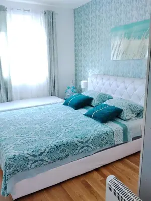 a bedroom with a white bed with blue pillows at Magnolia Lux Apartments - komplex Green Hill in Soko Banja