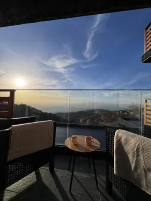 a balcony with a table and chairs and a large window at Apartman STARS in Kopaonik
