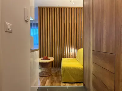 a small room with a yellow bed and a stool at Centar Crnjanski 2 in Jagodina