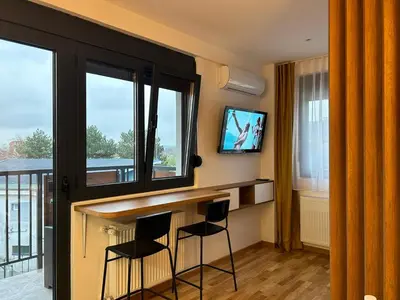 a room with a bar with two chairs and a tv at Centar Crnjanski 2 in Jagodina