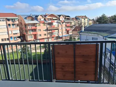 a balcony with a wooden door and some buildings at Centar Crnjanski 2 in Jagodina