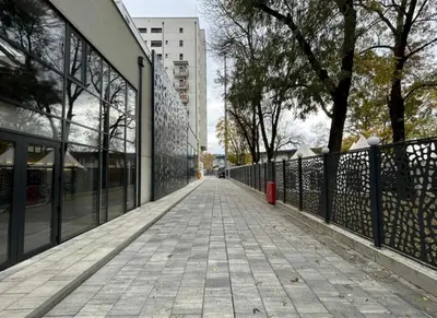a walkway with a fence and trees and a building at Centar Crnjanski 2 in Jagodina