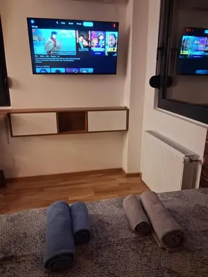 a living room with a tv and some towels on the floor at Centar Crnjanski 2 in Jagodina