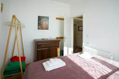 a bedroom with a purple bed and a dresser at Apartman Lusi Vranje in Vranje