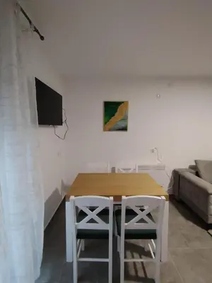 a dining room with a table and a couch at Everblue Chalet Kopaonik in Kopaonik