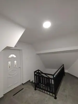 an attic room with a staircase and a white door at Everblue Chalet Kopaonik in Kopaonik