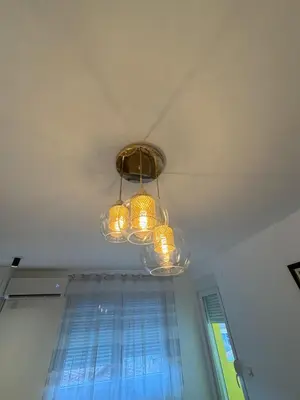 a chandelier hanging from a ceiling with a window at APARTMAN ANASTASIJA i DANKA in Pirot