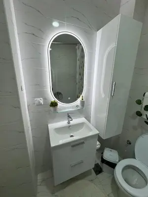 a white bathroom with a sink and a mirror at APARTMAN ANASTASIJA i DANKA in Pirot
