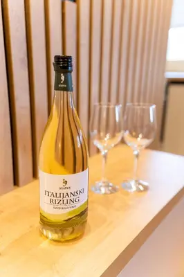 a bottle of wine sitting on a table with two wine glasses at APARTMAN ANASTASIJA i DANKA in Pirot