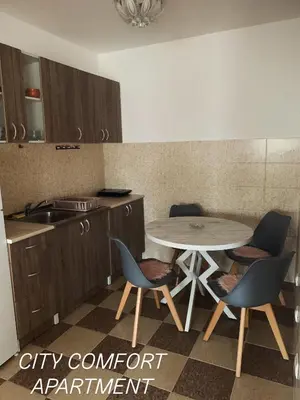 a kitchen with a table and chairs and a sink at City Comfort Apartment in Vranje