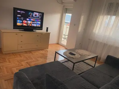 a living room with a couch and a tv on a dresser at City Comfort Apartment in Vranje