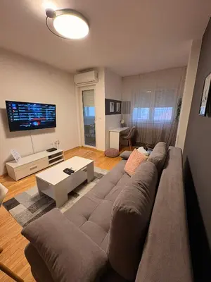 a living room with a large couch and a flat screen tv at NAR Royalton Apartment #27 Free Parking in Niš