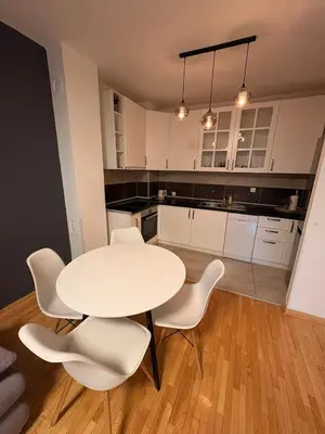 a kitchen with a white table and white chairs at NAR Royalton Apartment #27 Free Parking in Niš