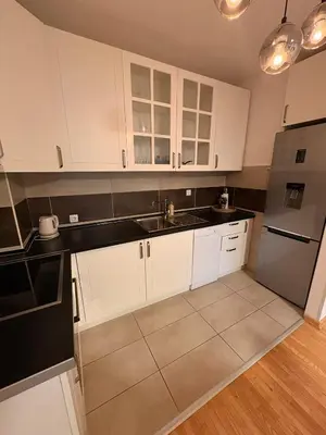 a kitchen with white cabinets and a stainless steel refrigerator at NAR Royalton Apartment #27 Free Parking in Niš