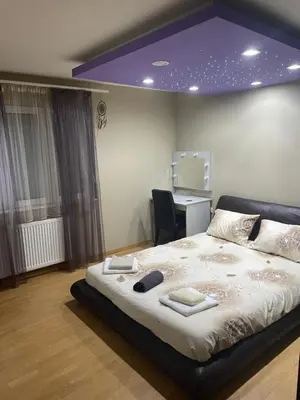 a bedroom with a large bed with a purple ceiling at Panorama Bulevar in Niš