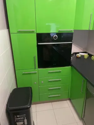 a green kitchen with green cabinets and a black oven at Panorama Bulevar in Niš