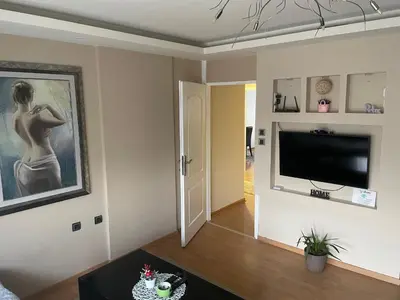 a living room with a flat screen tv on a wall at Panorama Bulevar in Niš