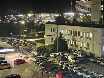 a parking lot with cars parked in front of a building at Panorama Bulevar in Niš