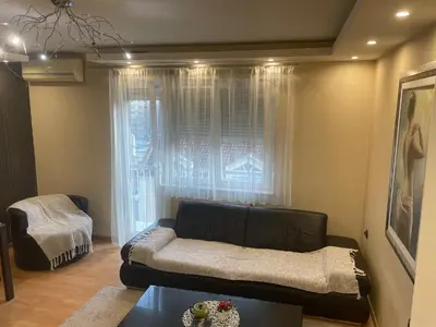 a living room with a couch and a window at Panorama Bulevar in Niš