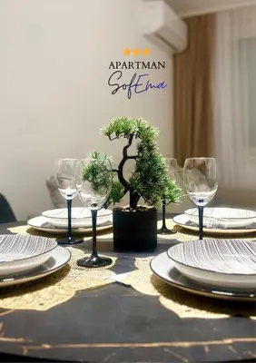 a table with plates and wine glasses and a tree on it at Sofema in Pirot