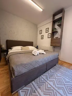 a bedroom with a large bed with a rug at NAR Royalton Suite #65 Free Parking in Niš