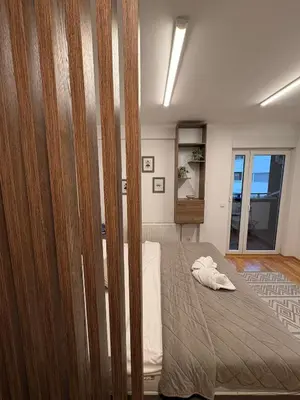 a bedroom with a large bed with a wooden closet at NAR Royalton Suite #65 Free Parking in Niš