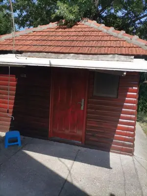 a small house with a red door and a blue stool at Panorama Borsko jezero in Beljevina