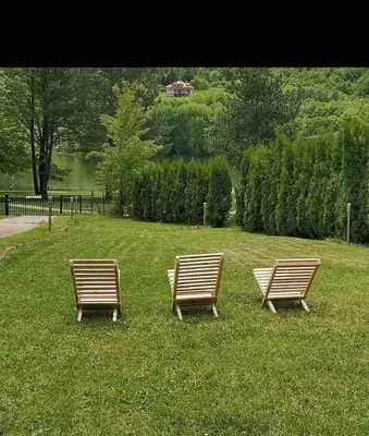 two benches sitting in the grass in a park at Panorama Borsko jezero in Beljevina