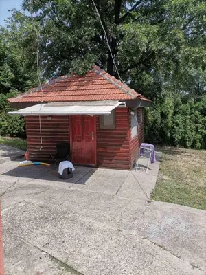 a smallshed with a red roof and a red door at Panorama Borsko jezero in Beljevina