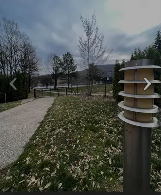 a pole with a sign on it in a park at Panorama Borsko jezero in Beljevina