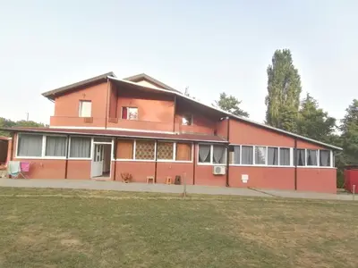 a large red building with a lot of windows at Panorama Borsko jezero in Beljevina
