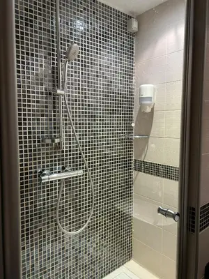 a shower with a glass door in a bathroom at Konaci Sun in Kopaonik