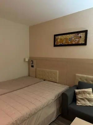 a small bedroom with a bed and a chair at Konaci Sun in Kopaonik