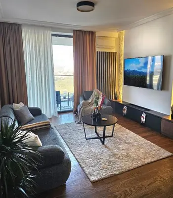 a living room with a large flat screen tv at Riviera Suite in Niš