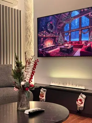 a living room with a tv hanging on the wall at Riviera Suite in Niš