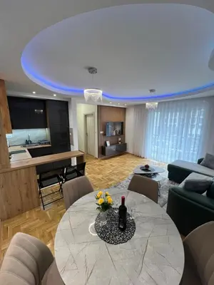 a living room with a table with flowers on it at Apartman LaCasa Mia in Vrnjačka Banja