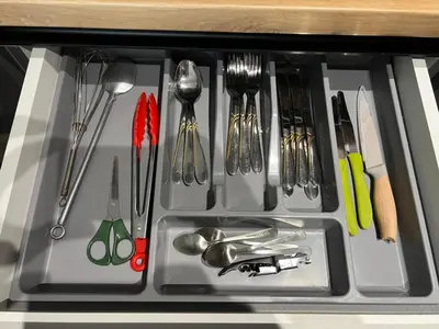 a drawer filled with utensils in a cabinet at Apartman LaCasa Mia in Vrnjačka Banja