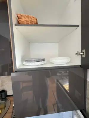 a cabinet with plates and dishes on it in a kitchen at Apartman LaCasa Mia in Vrnjačka Banja