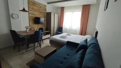 a living room with a blue couch and a table at Blistava Dolina S42 in Kopaonik