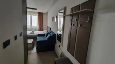 a living room with a blue couch and a mirror at Blistava Dolina S42 in Kopaonik